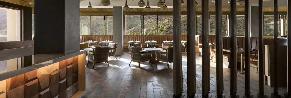 The sunlit seventh-floor 4 Saints dining room with mountain views through its windows.