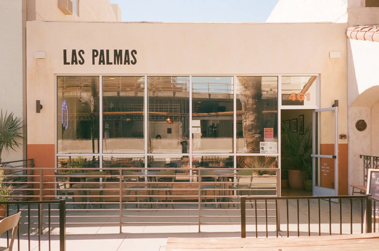 The Las Palmas Brewing storefront has wide windows, patio seating, and a large Las Palmas sign above the entrance.