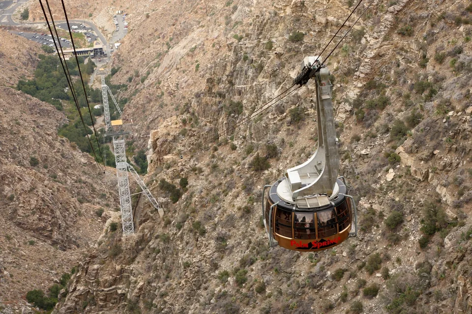 Palm Springs Aerial Tramway car suspended above the valley station in rocky Chino Canyon.
