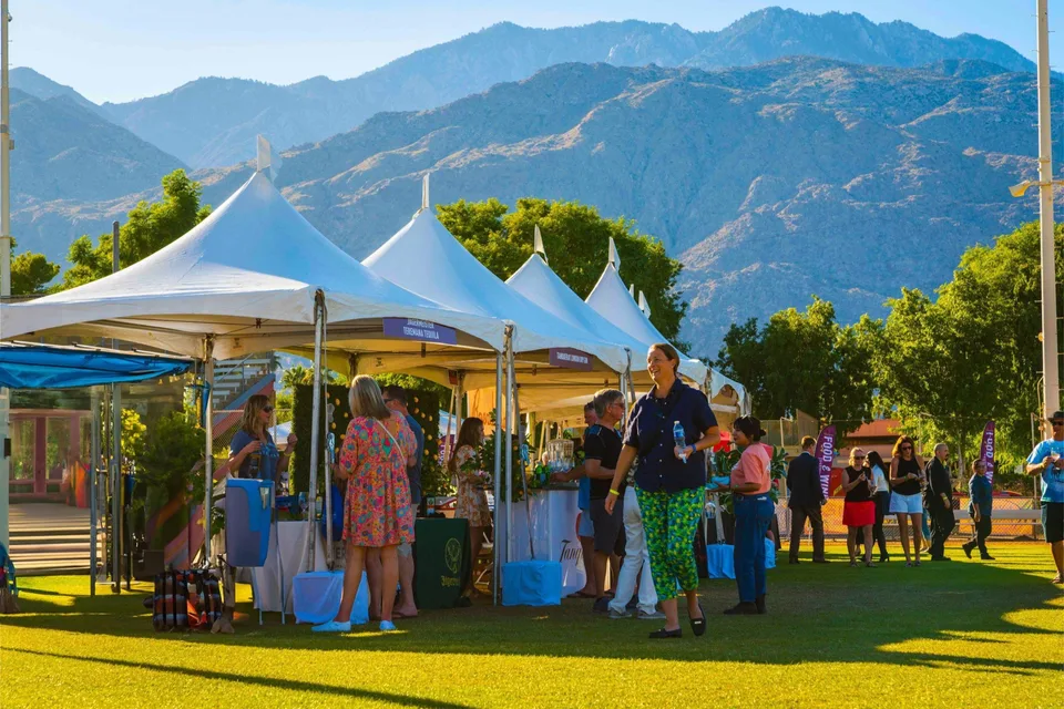 Visitors gather at food and wine tasting tents beneath the San Jacinto Mountains during the Palm Springs festival.