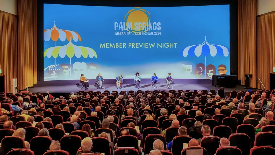 A full theater audience faces the Palm Springs International Film Festival member preview screen.