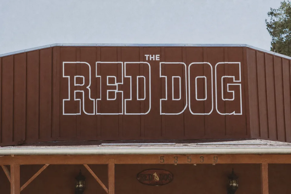 The rust-red Red Dog Saloon facade in Pioneertown with its large white outlined RED DOG sign above the entrance.